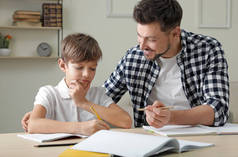 爸爸在家帮儿子布置学校作业