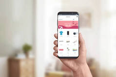 在现代智能手机上显示在线商店应用程序。网上购物的概念和抢手货,折扣营销。产品类别和购物车.