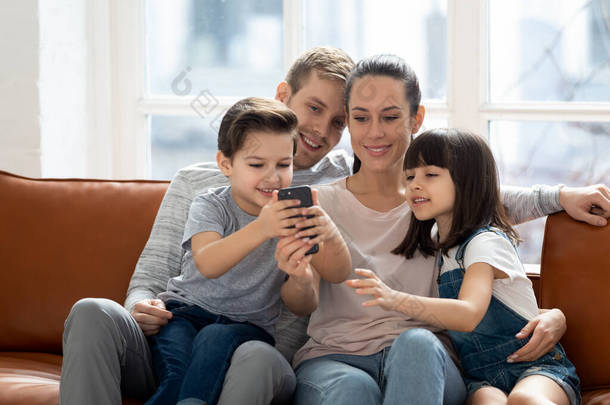 兴奋的家庭拥抱、娱乐、使用手机.