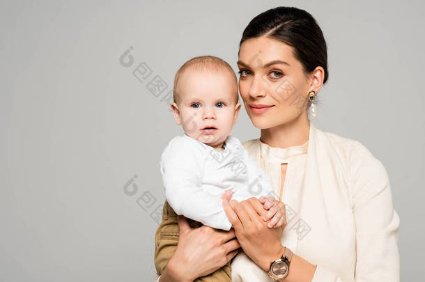 漂亮、快乐的女商人，手上拿着小宝宝，与灰色隔离