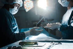 护士在制服和医疗面具给医疗设备给外科医生 