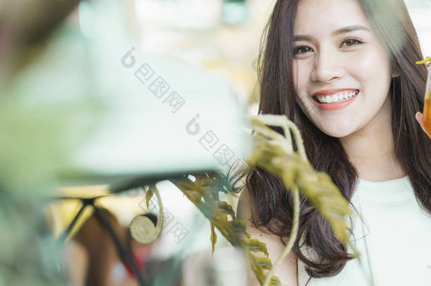 美丽的<strong>亚洲女人</strong>，美丽的笑容，健康的皮肤，绿叶树的肖像