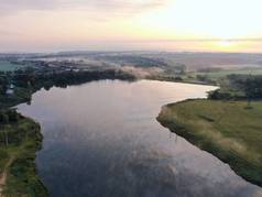 日落河的空中风景. 秋天的黎明时分，无人机飞过了这条河。 水面上的雾.