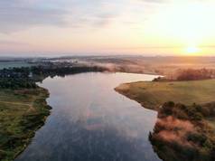 日落河的空中风景. 秋天的黎明时分，无人机飞过了这条河。 水面上的雾.