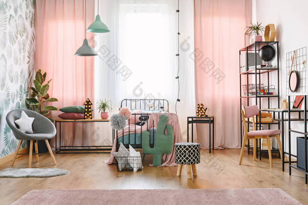 大窗口与粉红色窗帘, 彩球, 星和仙人掌枕头和一个金属单人床在一个甜蜜的卧室内部