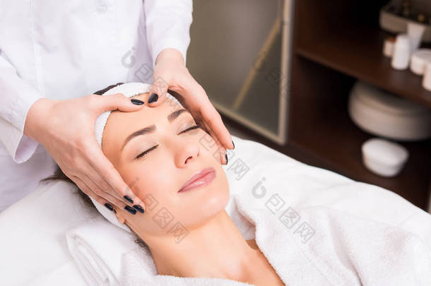 美容师在美容院做女人脸上的手动按摩