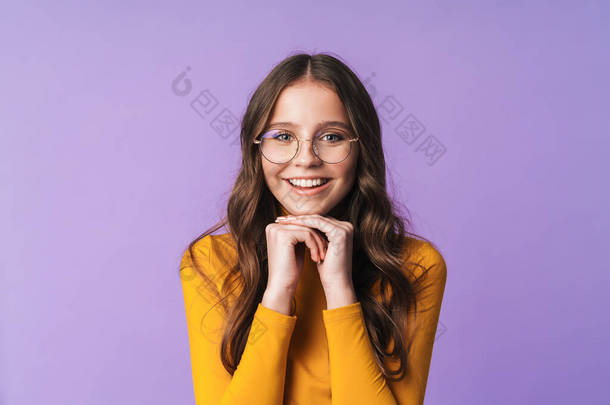 <strong>照片</strong>上年轻美丽的女人戴着眼镜，面带微笑，在紫罗兰色背景的相机前摆姿势