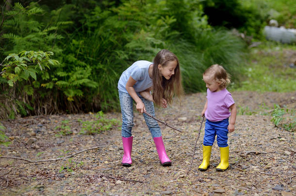 两个可爱的女孩在树林里玩. 