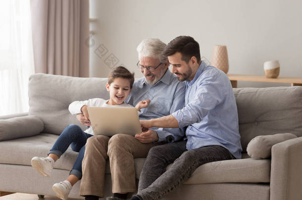 快乐三代家庭祖父父亲和孙子使用笔记本电脑