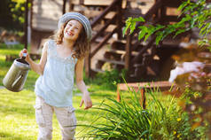 快乐的孩子在帽子里玩小园丁, 并帮助在暑假浇花