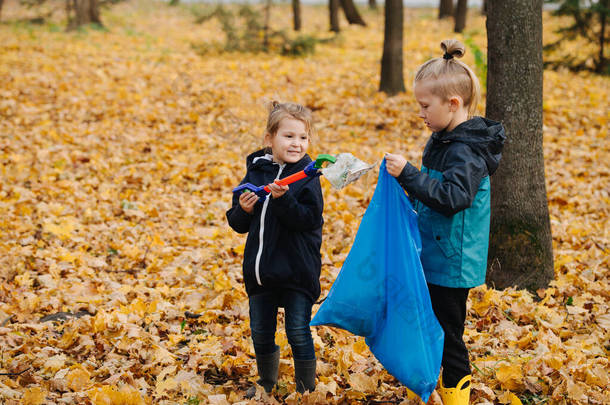 秋天的时候，孩子们用捡垃圾的工具在森林里捡垃圾