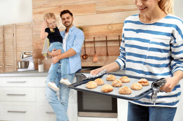 年轻女子在厨房用自制烤箱烤饼干对待家人