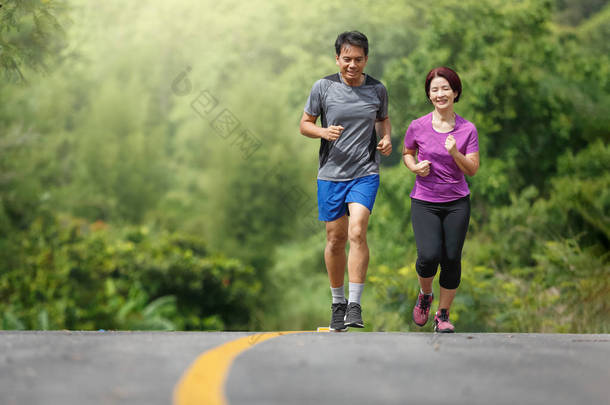 亚洲中年夫妇在公园慢跑运动