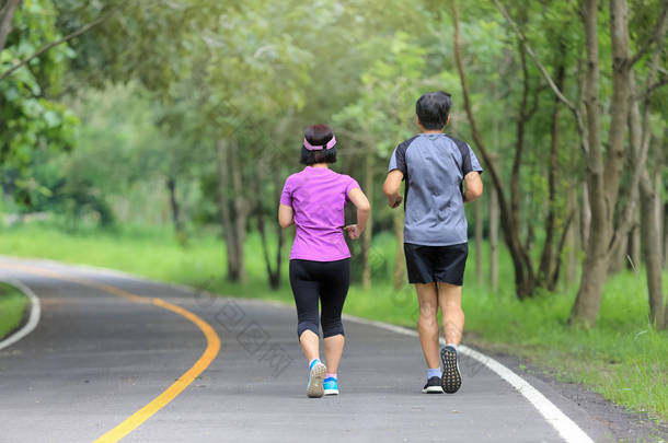 亚洲中年夫妇在公园慢跑和跑步