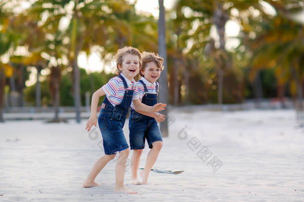 两个小孩子男孩快乐最好的朋友，玩沙子，友情观热带海滩上玩乐。兄弟姐妹文风在游泳裤。比斯坎，迈阿密，佛罗里达州