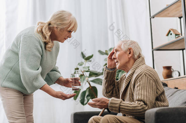 用拐杖给<strong>老人</strong>吃药和杯水的老年妇女