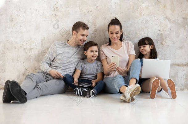 快乐的家庭，有两个可爱的孩子在智能手机上看视频.