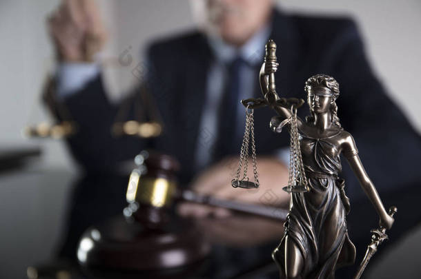 咨询律师的概念。办公室的律师在玻璃桌上的正义雕像, 槌和文件.