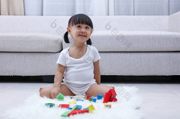 亚洲快乐在地板上玩积木的中国小女孩