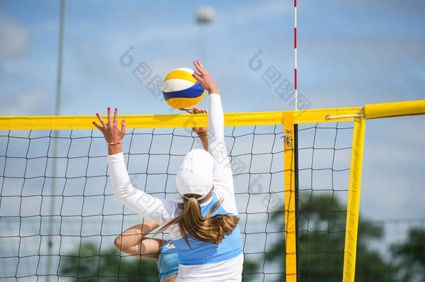 排球沙滩运动员是一名女子运动员, 在日落或日出时打沙滩排球