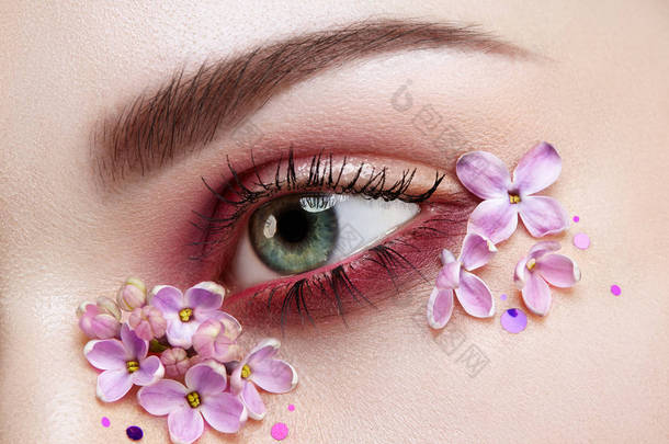 眼妆妇女与淡紫色花