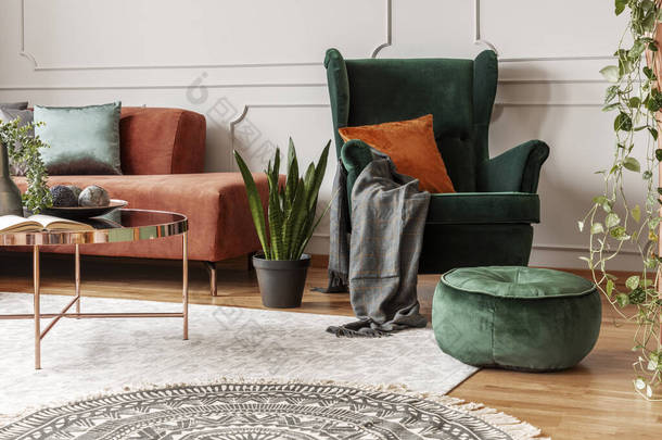 雅致客厅的棕色天鹅绒靠角沙发和翡翠绿色靠椅