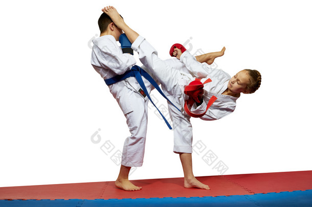 男孩和女孩在 karategi 跳动踢
