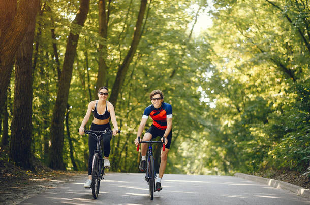 夏季森林里的一对运动型夫妇骑自行车