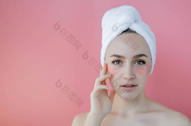 粉<strong>红背景</strong>的带眼斑美女的肖像。戴面具的女人容貌。护肤、化妆品概念与复印空间.