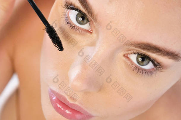 关闭美丽的面部皮肤和化妆的妇女的肖像, 应用睫毛膏睫毛 