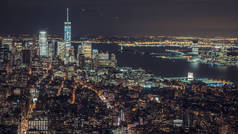美国，纽约城，曼哈顿空中全景市容的天际线。夜深了，汽车、 飞机和船只在河上的交通城市灯光