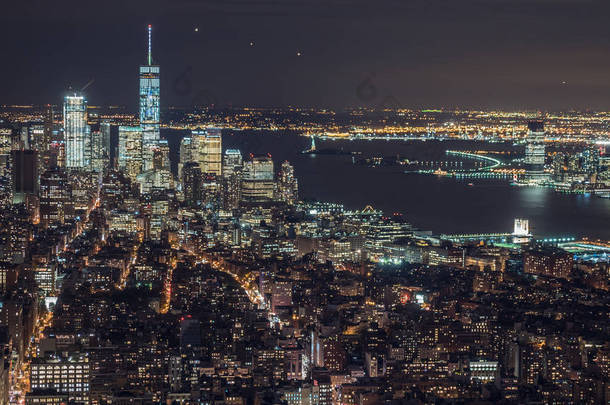美国，纽约城，曼哈顿空中全景市容的天际线。夜深了，汽车、 飞机和船只在河上的交通城市灯光