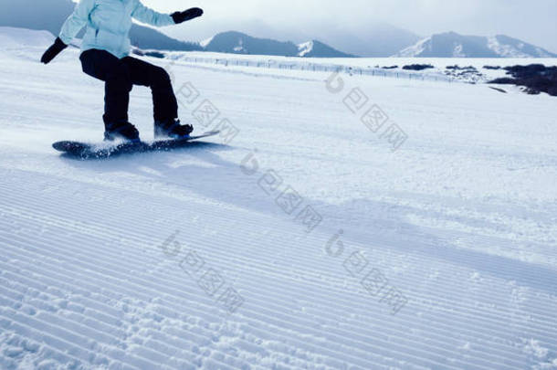 一个滑雪板滑雪板下降在冬季山区