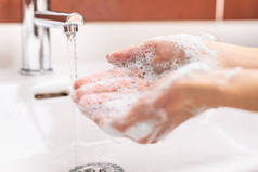 在浴室里用水和肥皂洗手。卫生防毒概念
