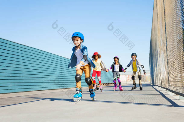 快乐的青春期男孩玩轮滑鞋与朋友户外在体育场