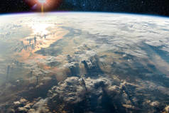 地球上长阴影的云彩和海洋中的阳光反射,这是美国宇航局提供的这张图片的元素.