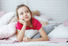 年轻的长发女孩在粉红色的 t恤躺在床上的枕头朦胧的查找