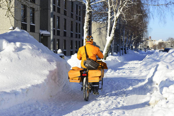 邮递员在芬兰的雪堆中骑自行车