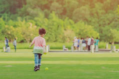 孩子喜欢在绿茵场上玩小球