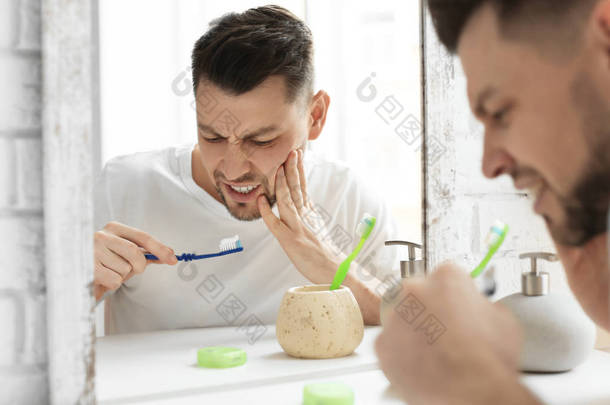 一个年轻人在浴室牙痛