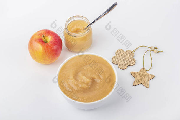 新鲜的自制苹果酱放在白碗里，并在白桌子上放上水果泥。适当营养和健康饮食的概念。有机和素食。婴儿食品。关上你
