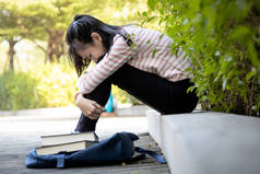 郁闷的亚洲女学生没能通过重要的考试，女学生坐着抱住她的膝盖直到膝盖