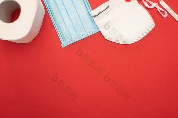 白色卫生纸、安全及医疗面罩及红底温度计的顶视图