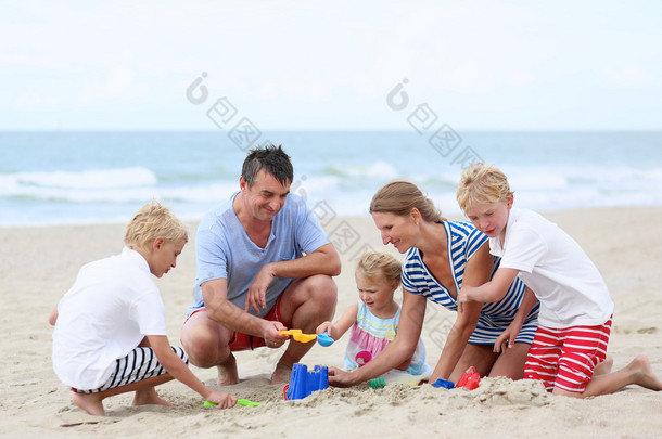 ευτυχισμένη οικογένεια των πέντε τη διασκέδαση στην παραλία