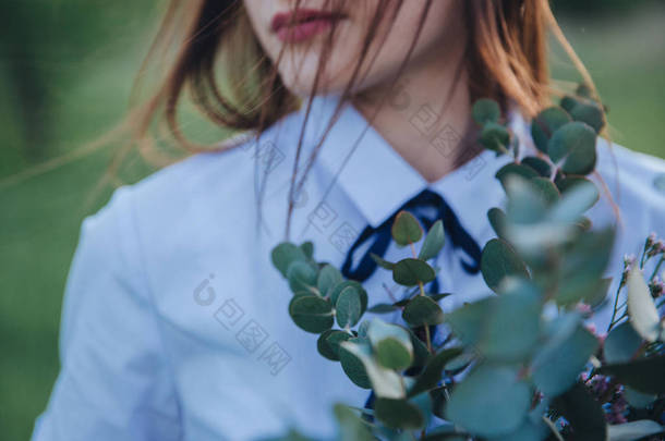 她手里拿着绿叶花束和鲜花的特写女孩