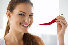 健康的食物。微笑的女士拿着红辣椒。生活方式饮食.