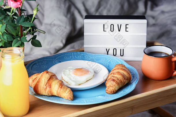 面包，咖啡和煎蛋，早餐在床上。 给你爱的人一个浪漫的早晨 有题词的光盒爱你