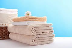 一堆干净柔软的毛巾, 洋甘菊花和洗衣篮上的蓝色