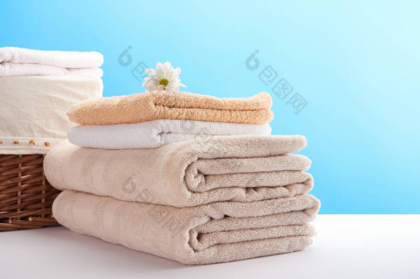 一堆干净柔软的毛巾, 洋甘<strong>菊花</strong>和洗衣篮上的蓝色