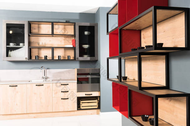 现代清洁光厨房的内部与厨房柜台和红色架子